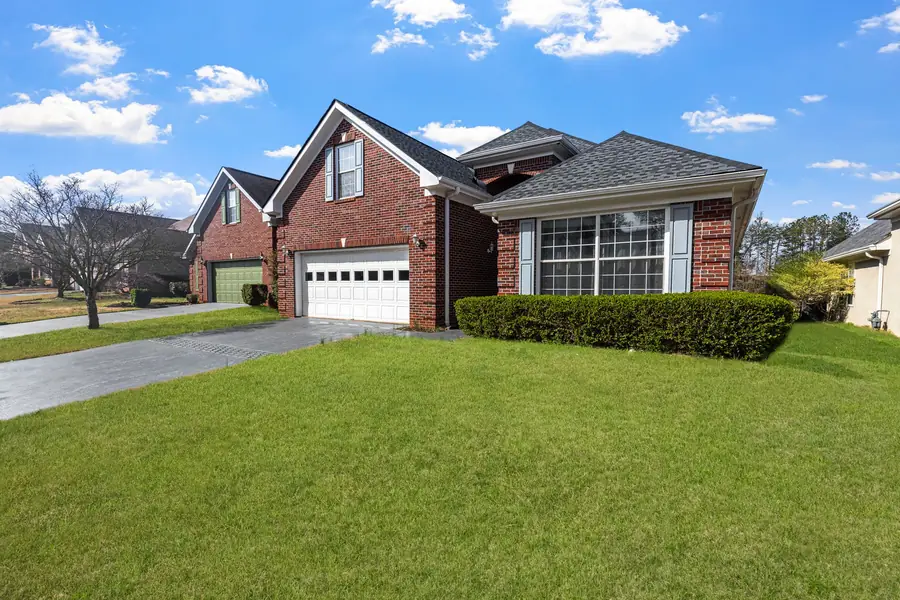 Single story brick home with a green front lawn