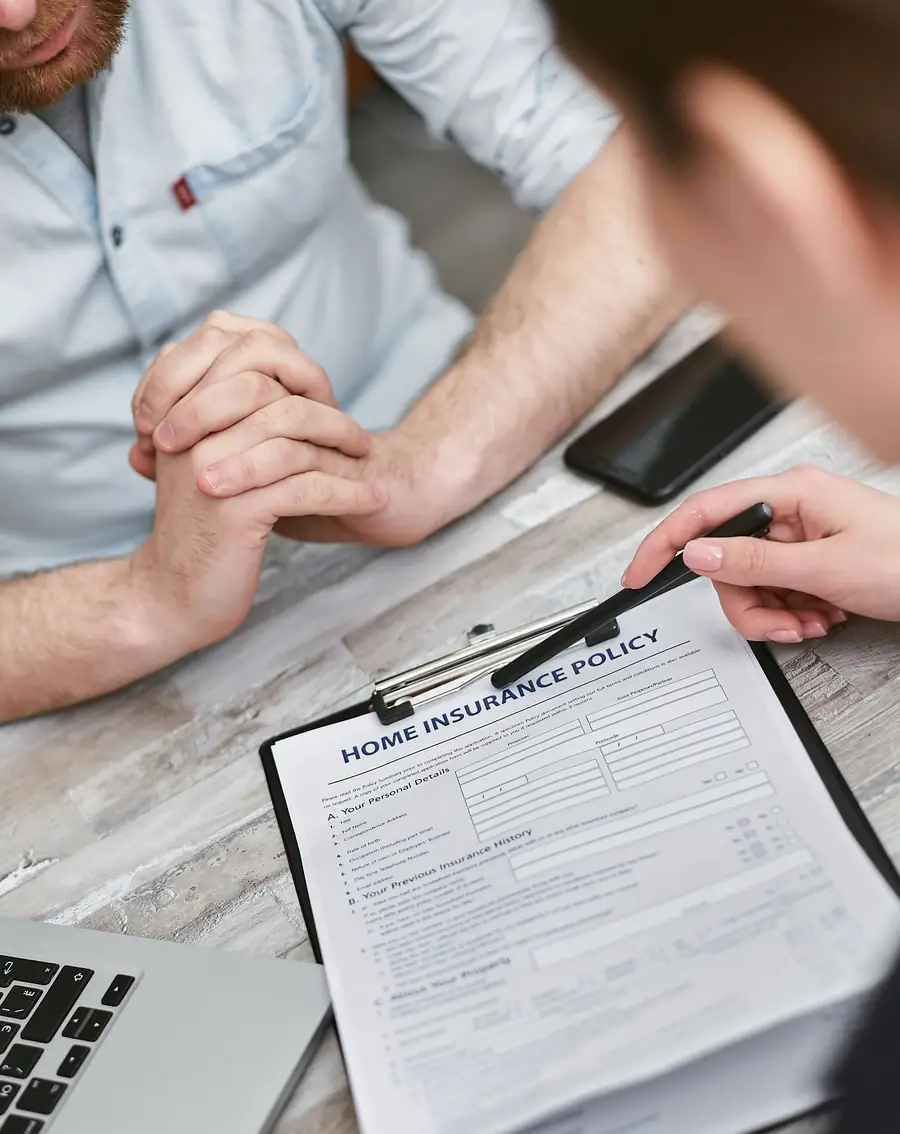 Two people reviewing a home insurance form on a clipboard
