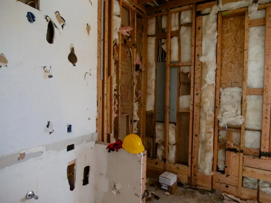 Room with damaged drywall removed down to the studs